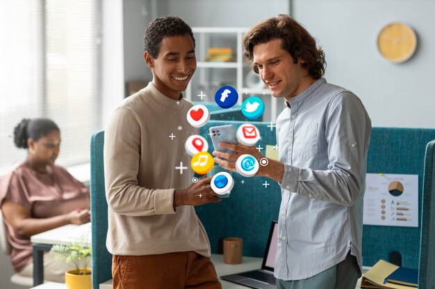 How to Reach and Engage Your Target Audience Online 2 Two colleagues smiling while using smartphones with floating social media icons.